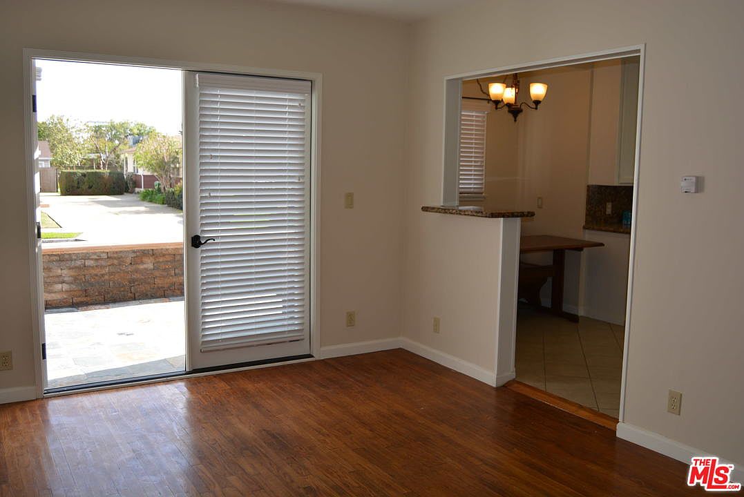 Interior of a unit with hardwood floors and sliding door to the yard